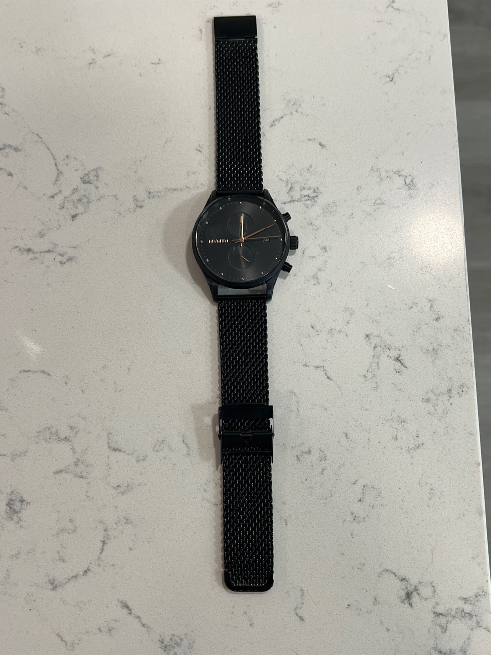 Black MVMT watch gold hands adjustable metal strap